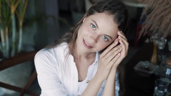 Portrait of Beautiful Brunette Woman in Cafe Looking at Camera