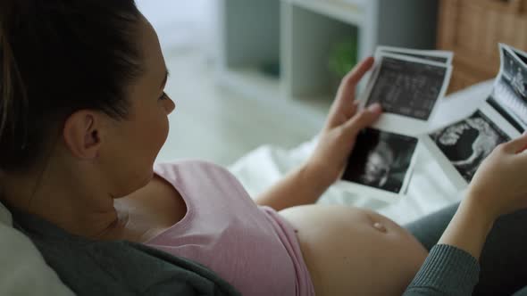 Tracking right video of pregnant woman browsing ultrasound images.