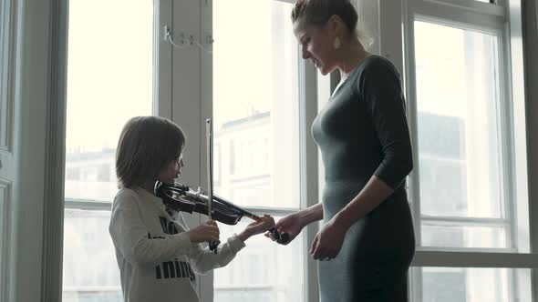 Teacher teaching boy playing violin during a lesson