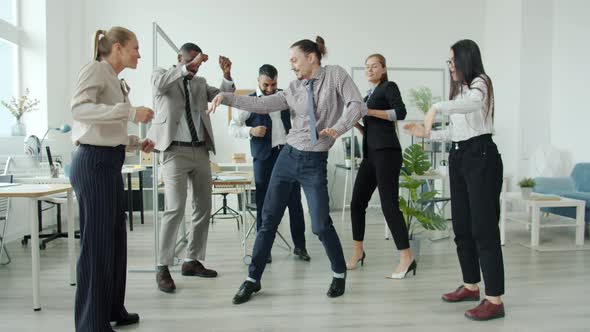 Slow Motion of Multiethnic Team Dancing Having Fun Together in Workplace