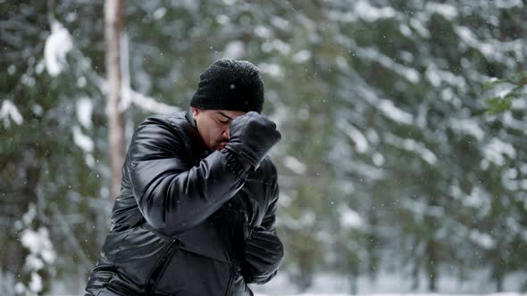 A Fighter Trains Outside in the Forest in Winter