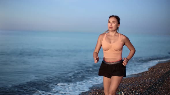 Sportswoman Running on Empty Beach at Sunrise Slow Motion