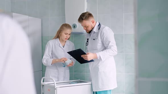 Nurse in White Lab Coat and Doctor with Stethoscope Counting Medicines or Recipes