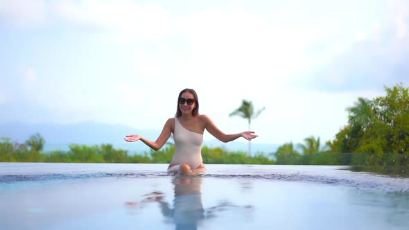 Young asian woman enjoy around outdoor swimming pool for leisure