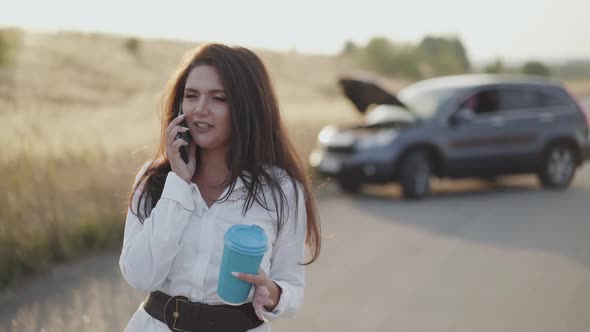 Alone Lady Holds a Cup of Tea and Emotionally Talks on Phone at Broken Car