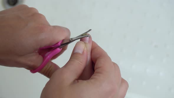 Mom cuts her daughter's nails.