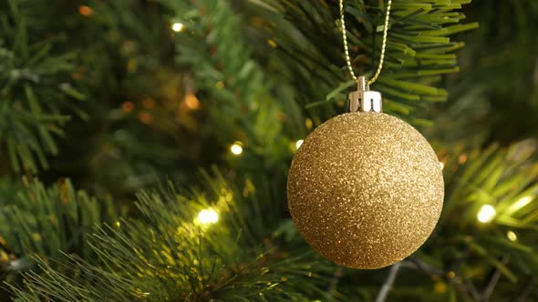 Golden decorative bauble on  the Christmas tree 4K 2160p 30fps UltraHD footage - Sequins on round  o