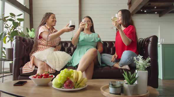 Three Mixed Race Women Sitting on Couch Drinking and Relaxing at Home