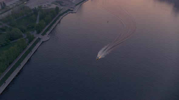 An Aerial View of a Boat That Floats on a River in the City Centre at Sunset