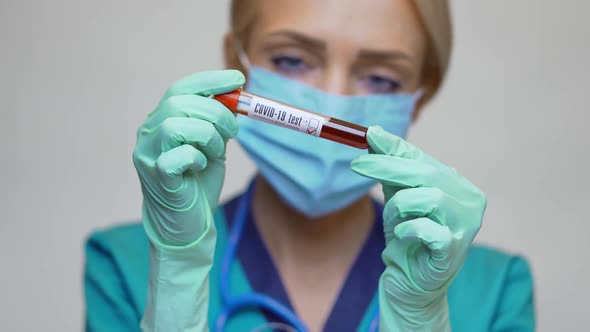 Medical Doctor Nurse Woman Wearing Protective Mask and Gloves - Holding COVID-19 Negative Blood Test