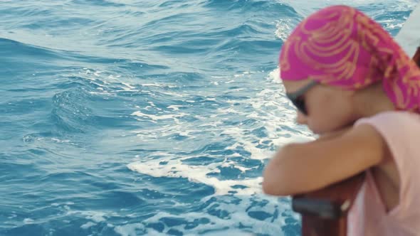 Thoughtful Girl Looking at Water Surface During Cruise on Yacht