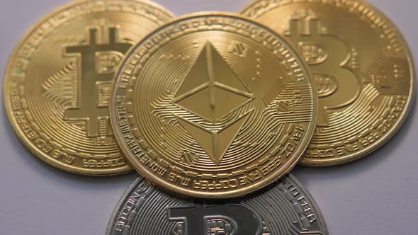 Four Gold and Silver Iron Coin Ethereum and Bitcoin on Gray Background