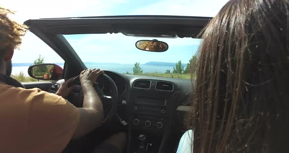 Handsome black man turning on a highway in convertible car