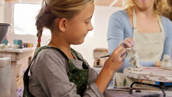 Mother and daughter making a toy from clay