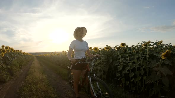 Sporty Girl Riding Bicycle Between Sunflower Fields