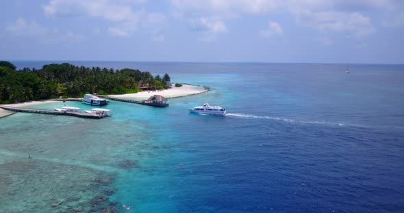 Wide birds eye tourism shot of a white paradise beach and aqua turquoise water background in vibrant