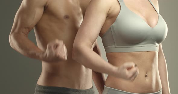 Closeup of Two Athletes Male and Female Bare Chests with Abdominal Abs
