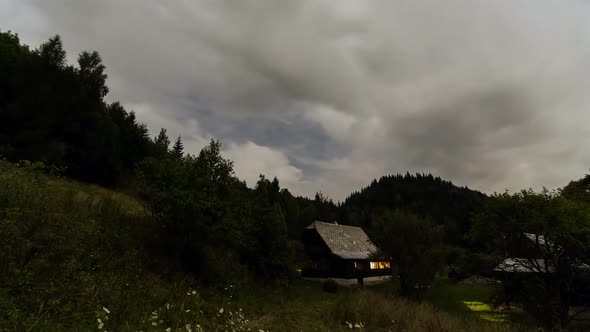Clouds Moving over Cottage at Moonlight Night. Romantic Evening in Wood Cabin