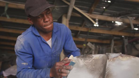 African man sanding a car