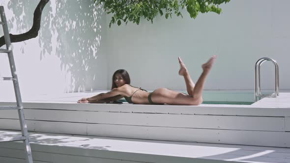 Young woman lying by the pool.