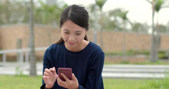 Asian student work on smart phone in park