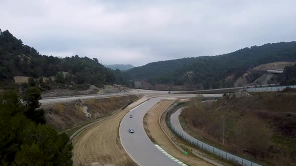 aerial drone shot of sports cars in a section of the castelloli circuit