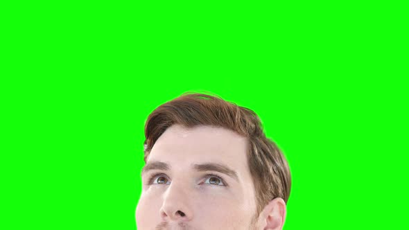 Caucasian man looking up on green background