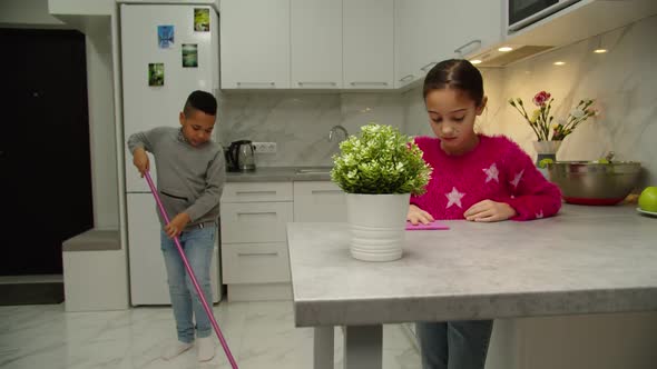 Multiethnic Children Cleaning Kitchen Doing Housekeeping Job Indoors