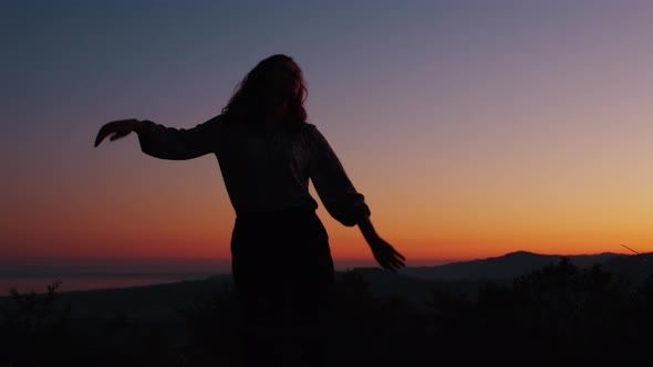 Silhouette of a Dancing Girl at Sunset Light