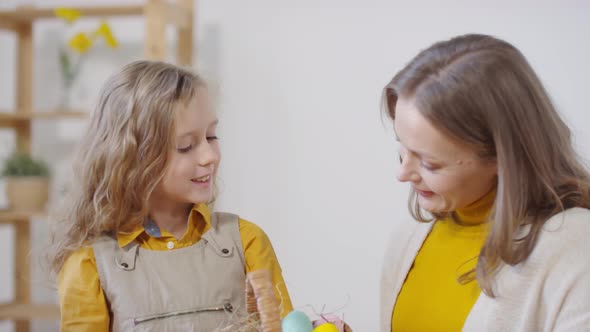 Happy Woman and Girl with Basket of Easter Eggs