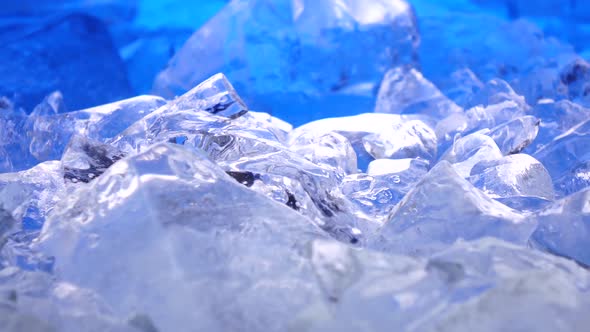 Pieces of Ice Lies on the Table, Blue Illumination Beautifully Lies Over Fragments. Close Up