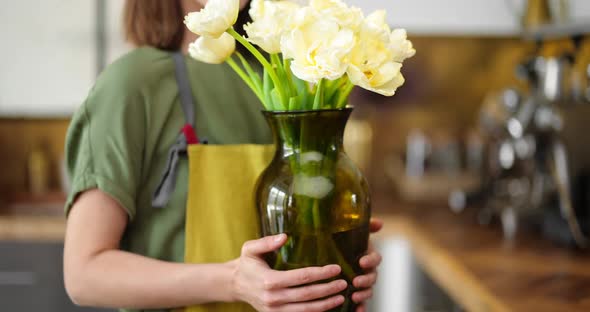 Woman Decorates Home Interior with a Bouquet of Fresh Flowers