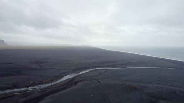 Aerial view over Black Sand Beach In Iceland on a cloudy day.