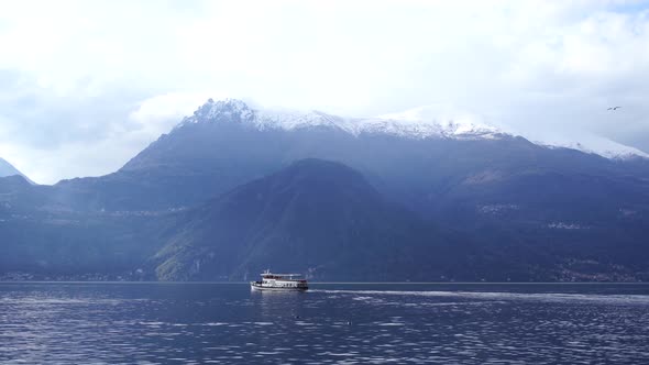 Passenger Ferry Floats on Lake Como Against the Backdrop of Mountains