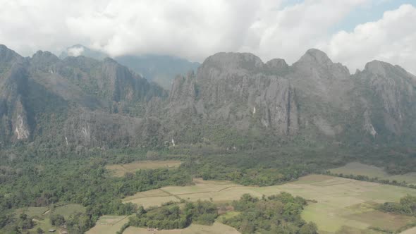 Aerial: flying over scenic cliffs rock pinnacles tropical jungle rice paddies