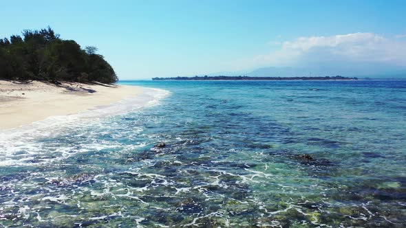 Luxury fly over travel shot of a summer white paradise sand beach and blue water background in color