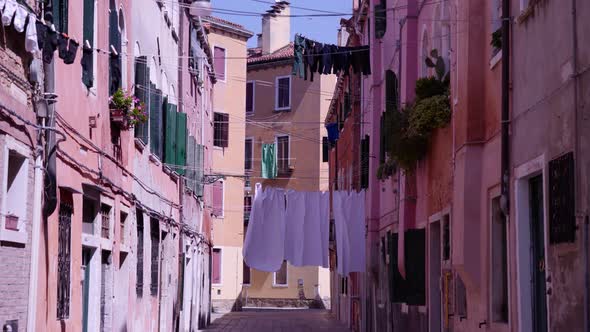 Clean Laundry Dried on Ropes Between Buildings on Street