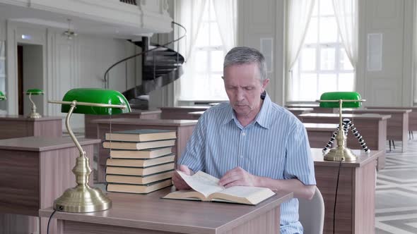 Senior Man with Mustache Reading a Book