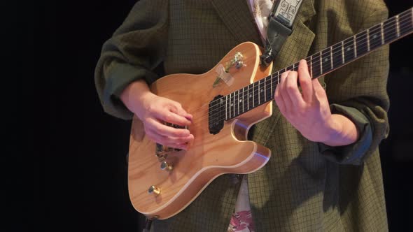 Jazz Guitarist in a Green Jacket Plays at a Concert