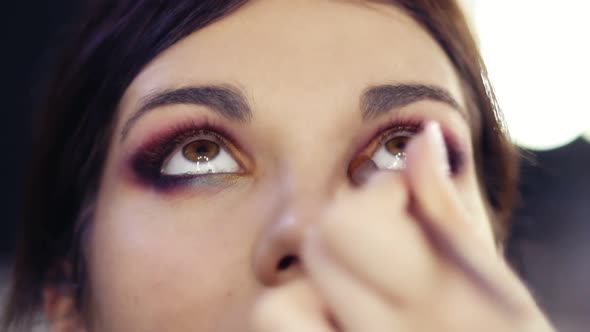 Adding Some Gold Pigmented Eyeshadow in Inner Corner of Beautiful Brunette Girl's Eyes