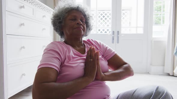 Senior african american woman practicing yoga in bedroom at home