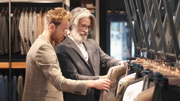 Man Trying Business Suit on with Consultant at Men Clothing Store