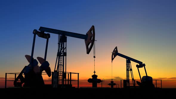 Two Oil Pump Jacks Extracting Crude Oil Under Beautiful Sunset Sky