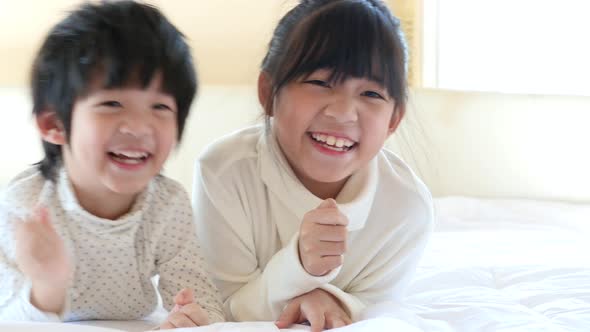 Cute Asian Children Playing On White Bed