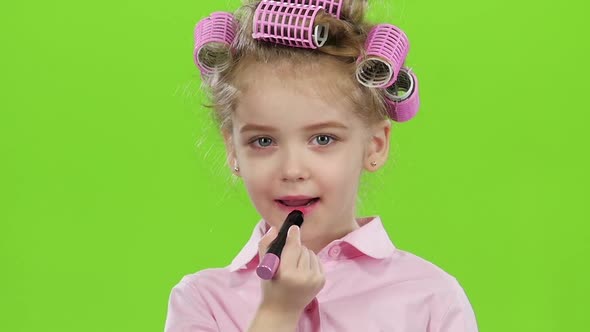 Little Girl Paints Her Lips with Beautiful Lipstick. Green Screen. Slow Motion