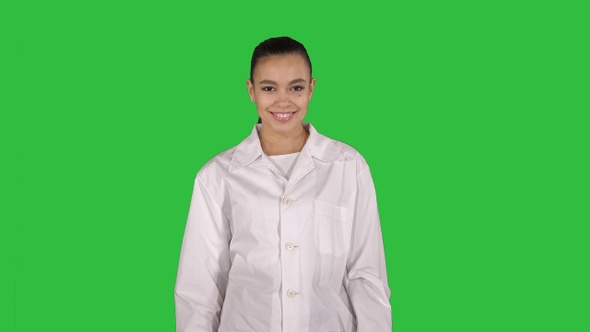 Happy young woman doctor dances on a Green Screen, Chroma Key.