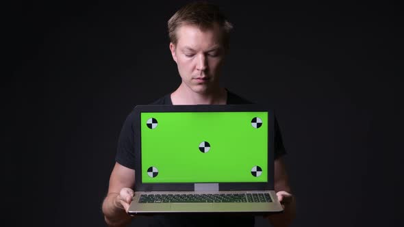 Young Handsome Man Using Laptop with Green Screen Chroma Key