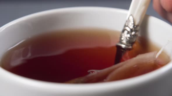 Teaspoon Stir black tea with a teabag in a white cup