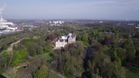 Rotating around Schloss Wolfsburg Castle and forest, Aerial shot, Germany