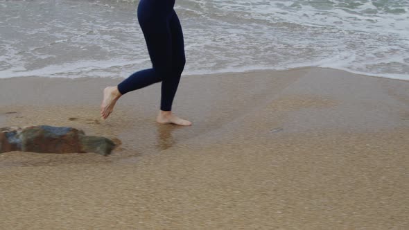 Athletic Woman Is Jogging On Beach